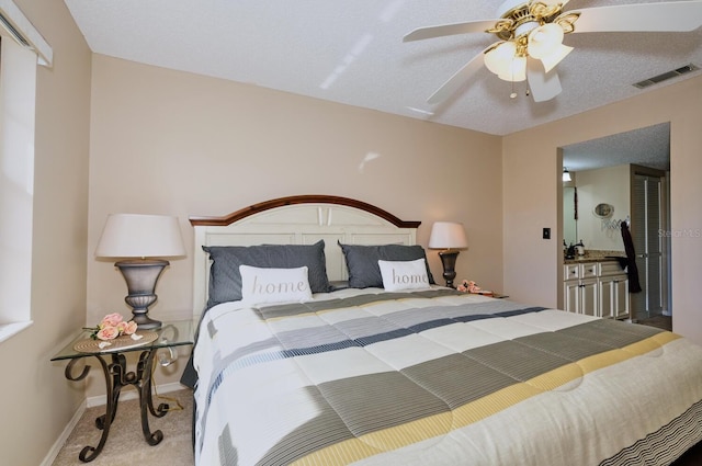 carpeted bedroom featuring ceiling fan and a textured ceiling