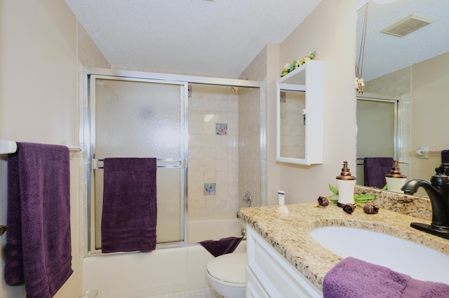 full bathroom featuring tile patterned floors, bath / shower combo with glass door, vanity, a textured ceiling, and toilet