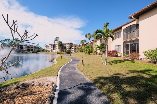 view of home's community featuring a water view and a lawn