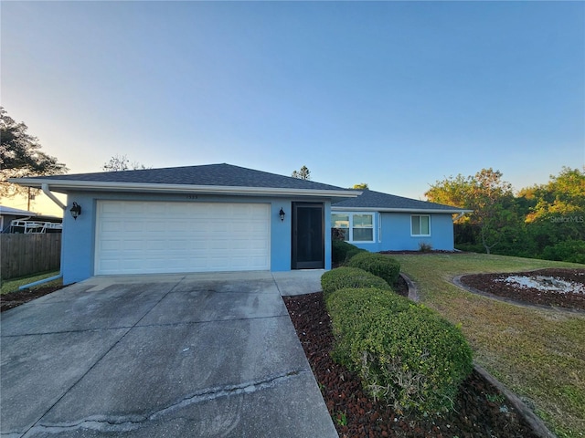 single story home with fence, a front yard, stucco siding, a garage, and driveway