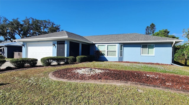 ranch-style house with stucco siding, an attached garage, roof with shingles, and a front yard