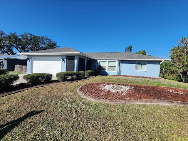 ranch-style house with stucco siding, an attached garage, and a front lawn