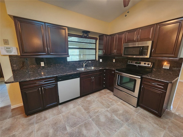 kitchen featuring sink, dark stone counters, lofted ceiling, and appliances with stainless steel finishes