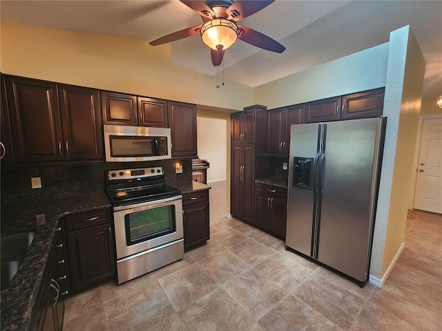 kitchen featuring ceiling fan, dark brown cabinets, stainless steel appliances, and dark stone counters