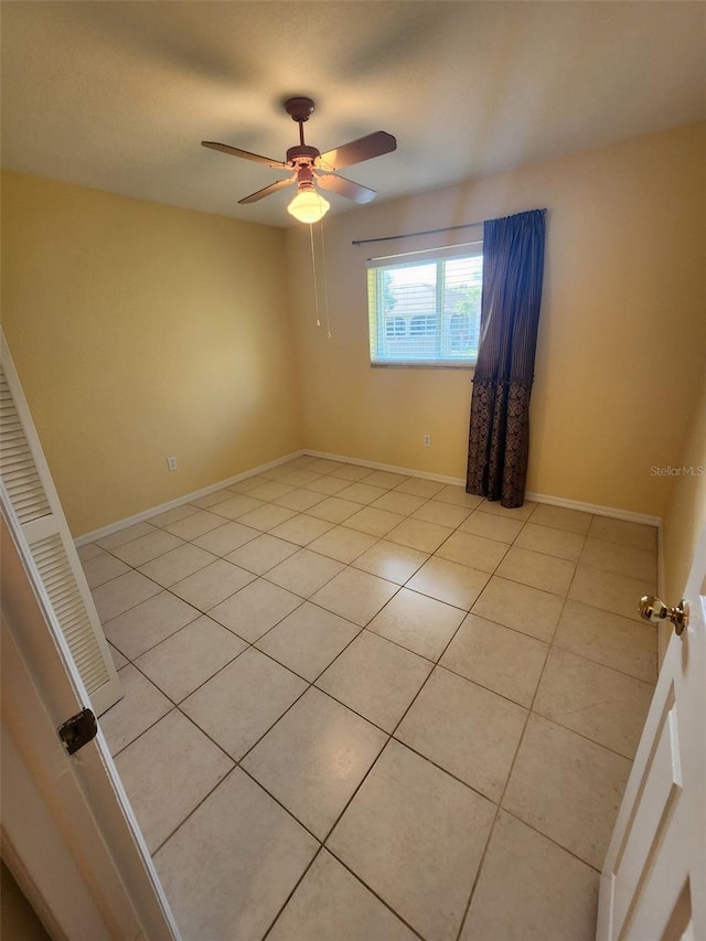 empty room featuring ceiling fan and light tile patterned flooring