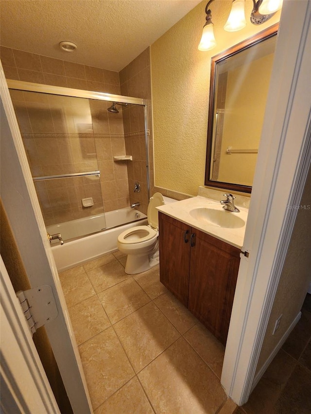 full bathroom with vanity, combined bath / shower with glass door, a textured ceiling, and toilet