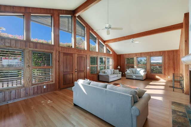 living room featuring a wealth of natural light, light hardwood / wood-style flooring, and beamed ceiling