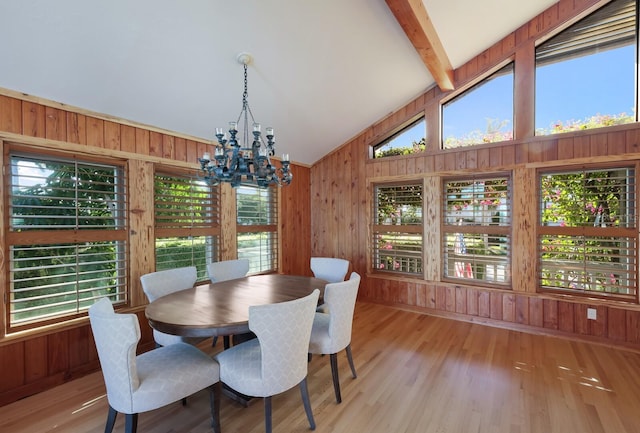 dining room with lofted ceiling with beams, light hardwood / wood-style floors, plenty of natural light, and a notable chandelier