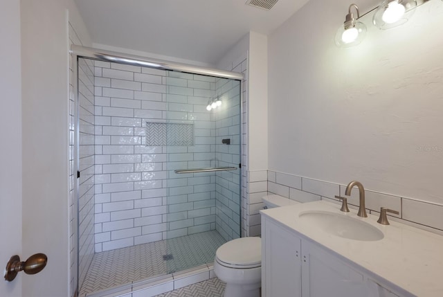 bathroom featuring tile patterned flooring, vanity, toilet, and an enclosed shower