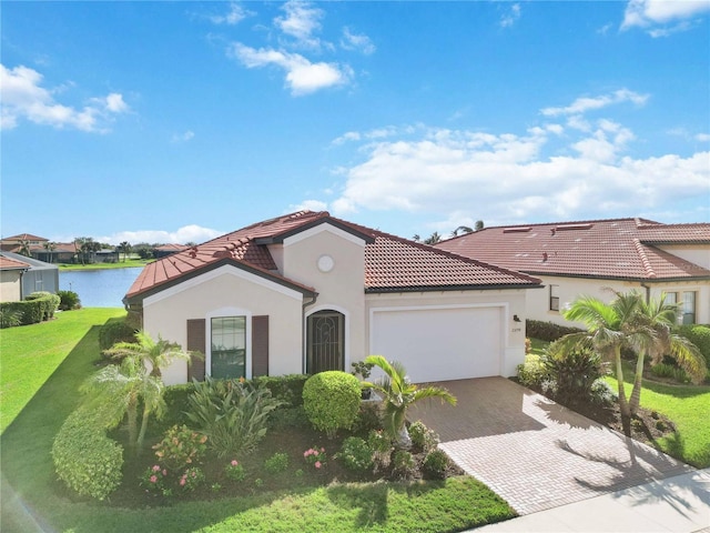 mediterranean / spanish-style house featuring a front yard, a water view, and a garage