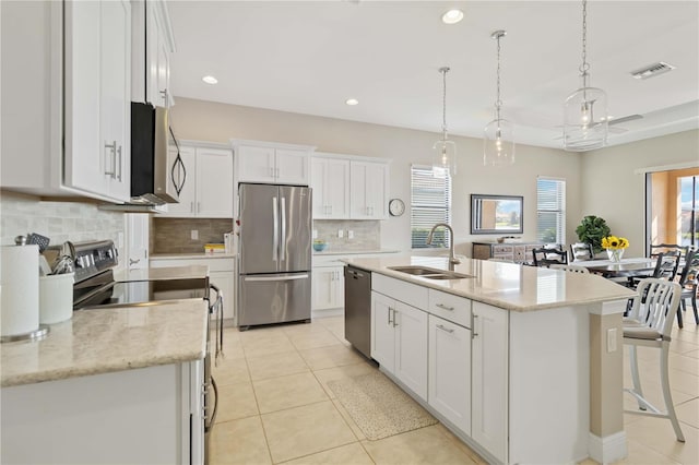 kitchen featuring a center island with sink, sink, white cabinetry, pendant lighting, and stainless steel appliances