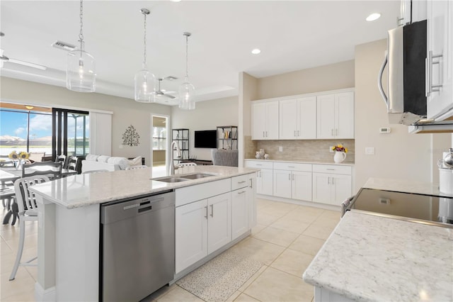 kitchen featuring sink, appliances with stainless steel finishes, white cabinets, and an island with sink