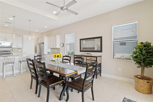 tiled dining space with ceiling fan