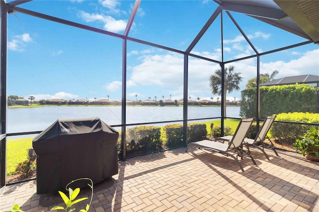 view of patio featuring a water view, a lanai, and grilling area