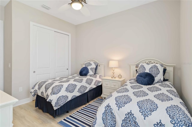 bedroom featuring ceiling fan, light wood-type flooring, and a closet