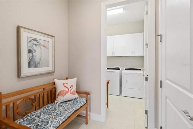 washroom with washer and dryer and cabinets