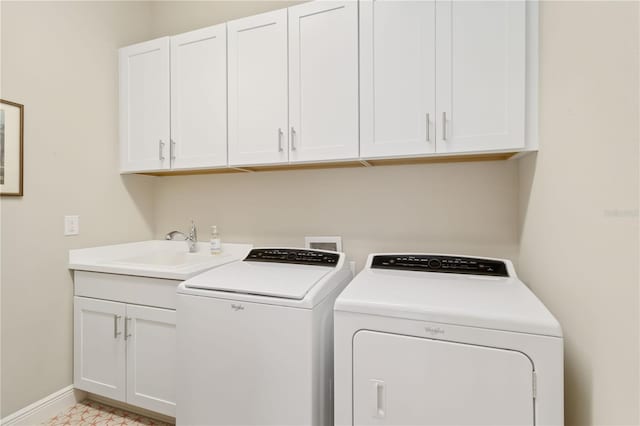 clothes washing area featuring cabinets, washer and clothes dryer, and sink