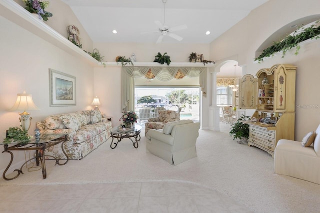 living room featuring light tile patterned flooring, ceiling fan, vaulted ceiling, and a wealth of natural light