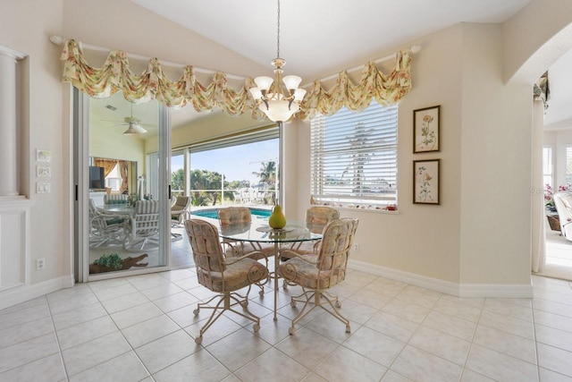 tiled dining room featuring lofted ceiling and a chandelier