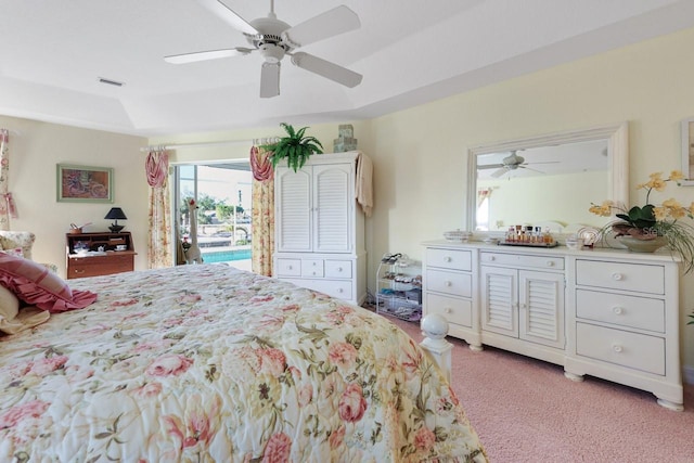 bedroom with ceiling fan, a raised ceiling, light colored carpet, and access to outside