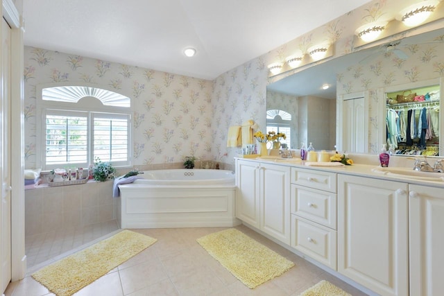 bathroom with tile patterned flooring, vanity, and a bath