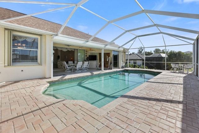 view of swimming pool featuring a patio and glass enclosure