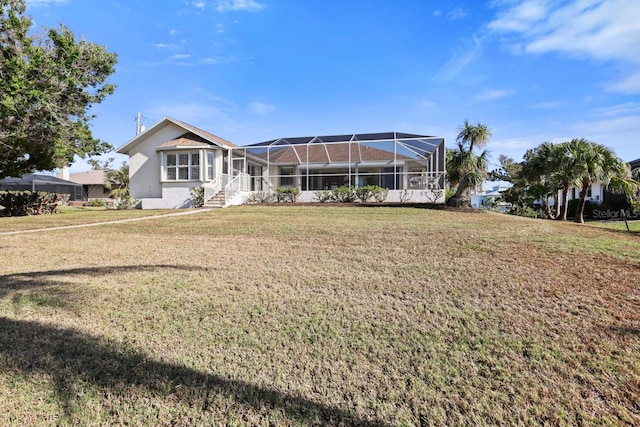 back of property featuring a yard and glass enclosure