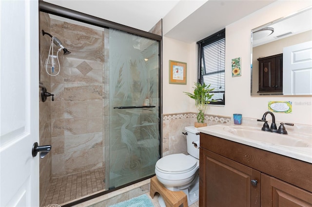 bathroom featuring walk in shower, vanity, tile walls, and toilet