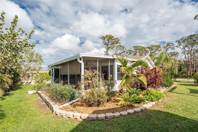 view of home's exterior featuring a sunroom and a lawn