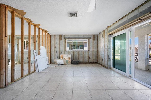 interior space featuring a textured ceiling, a wealth of natural light, and light tile patterned flooring