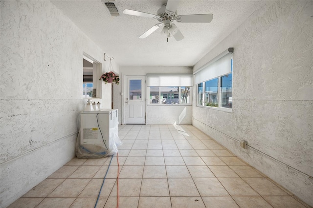 unfurnished sunroom with ceiling fan