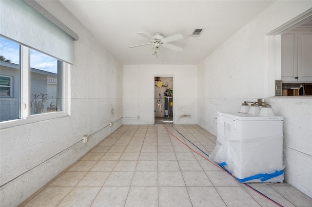 tiled spare room with electric water heater and ceiling fan