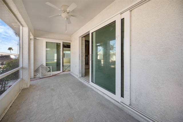 unfurnished sunroom featuring ceiling fan