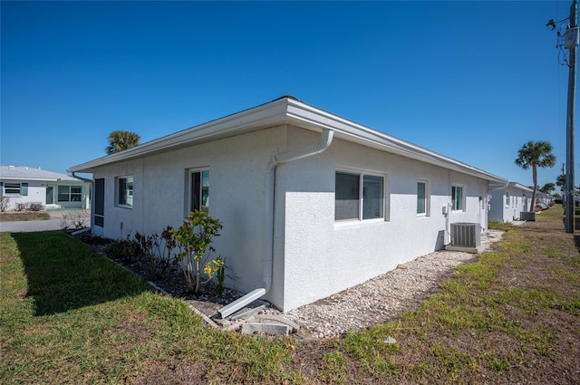 view of side of property featuring a yard and central AC unit