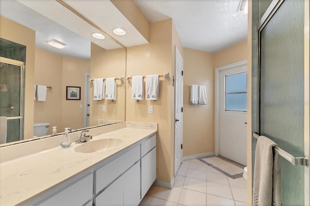 bathroom with tile patterned flooring, a textured ceiling, toilet, vanity, and a shower with shower door