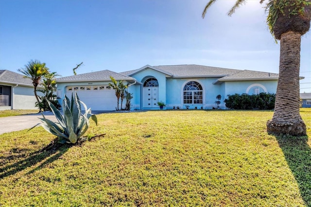 ranch-style house with a garage and a front lawn