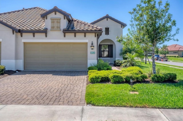 mediterranean / spanish-style house featuring a garage and a front yard