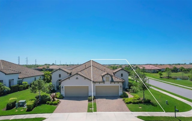 mediterranean / spanish-style home with a garage and a front lawn