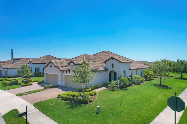 mediterranean / spanish home with a front lawn and a garage