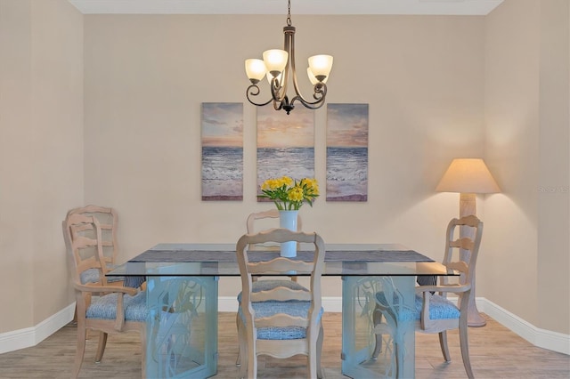 dining room featuring hardwood / wood-style flooring and an inviting chandelier