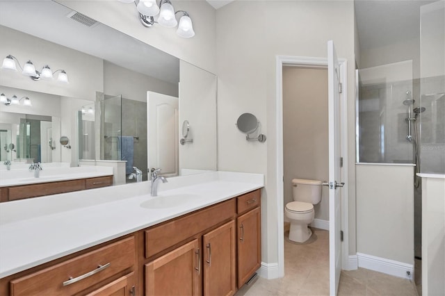 bathroom featuring tile patterned flooring, a tile shower, vanity, and toilet