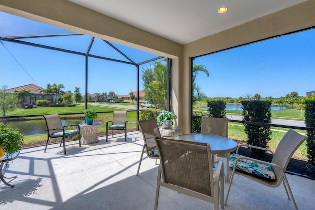 view of patio with a water view and a lanai