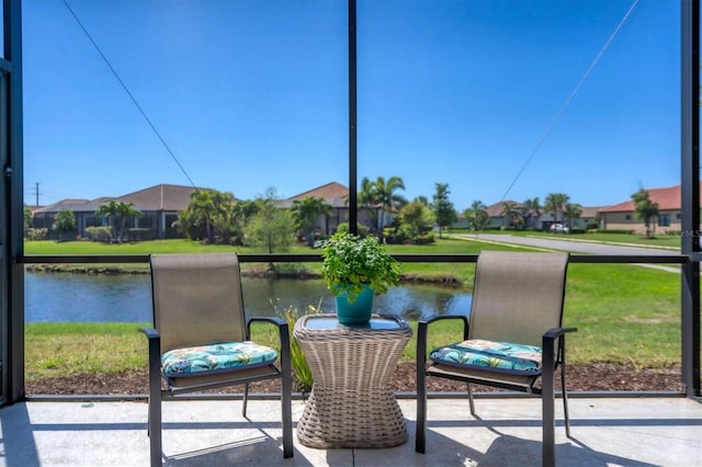 sunroom featuring a water view