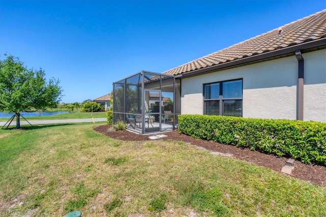 view of yard with a water view and a lanai