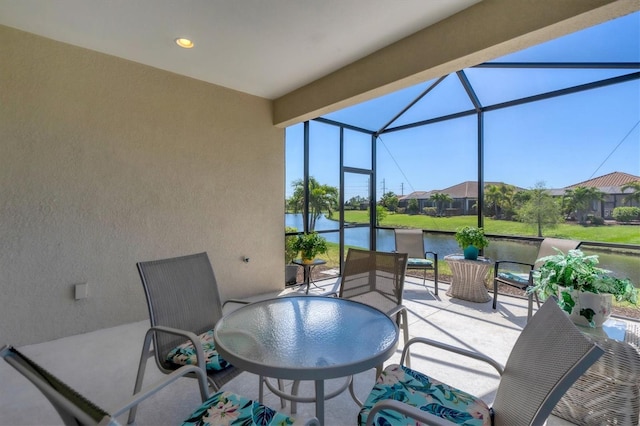 view of patio featuring a lanai and a water view