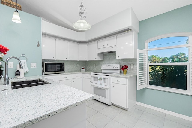 kitchen featuring range with two ovens, white cabinetry, and sink