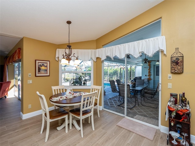 dining room featuring a healthy amount of sunlight, a notable chandelier, and light wood-type flooring