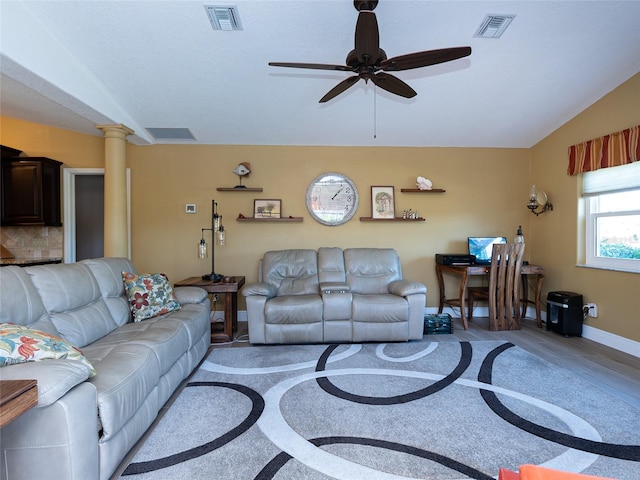 living room featuring decorative columns, ceiling fan, light hardwood / wood-style floors, and lofted ceiling