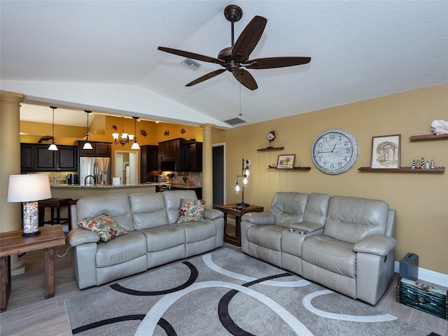 living room featuring light hardwood / wood-style flooring, ceiling fan with notable chandelier, and vaulted ceiling