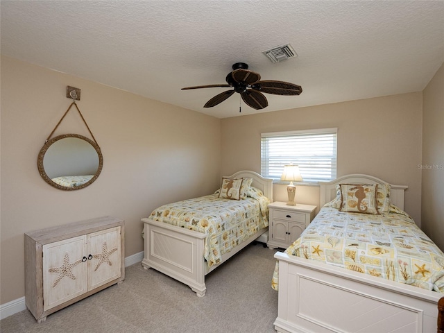 carpeted bedroom featuring ceiling fan and a textured ceiling